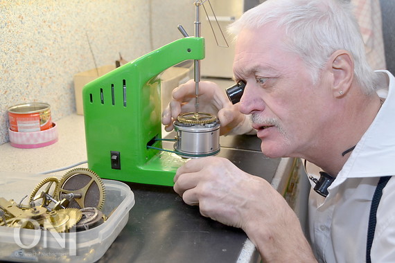 Werner Kaluza prüft ein Zahnrad aus einem mechanischen Uhrwerk.