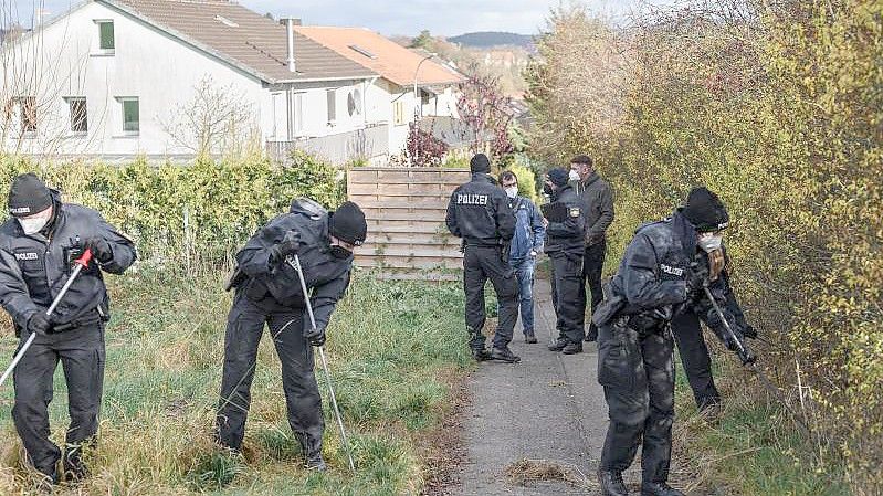 Eine Einheit der Bereitschaftspolizei durchsucht das Gelände um den Tatort in Bad Neustadt nach Spuren. Foto: Daniel Vogl/dpa