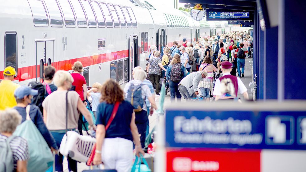 Touristen gehen über den Bahnsteig Norddeich-Mole, um in einen IC der Deutschen Bahn (DB) einzusteigen. Zurzeit wird darum gerungen, ob das Deutschlandticket auch hier gelten wird. Foto: DPA