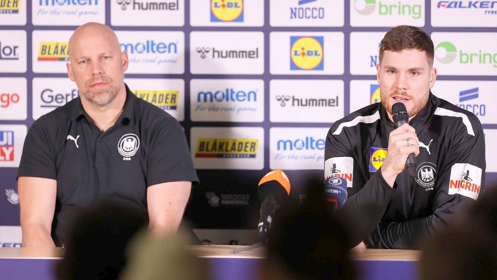 Axel Kromer (l) und Kapitän Johannes Golla sitzen während einer Pressekonferenz auf dem Podium. Foto: Jan Woitas/dpa