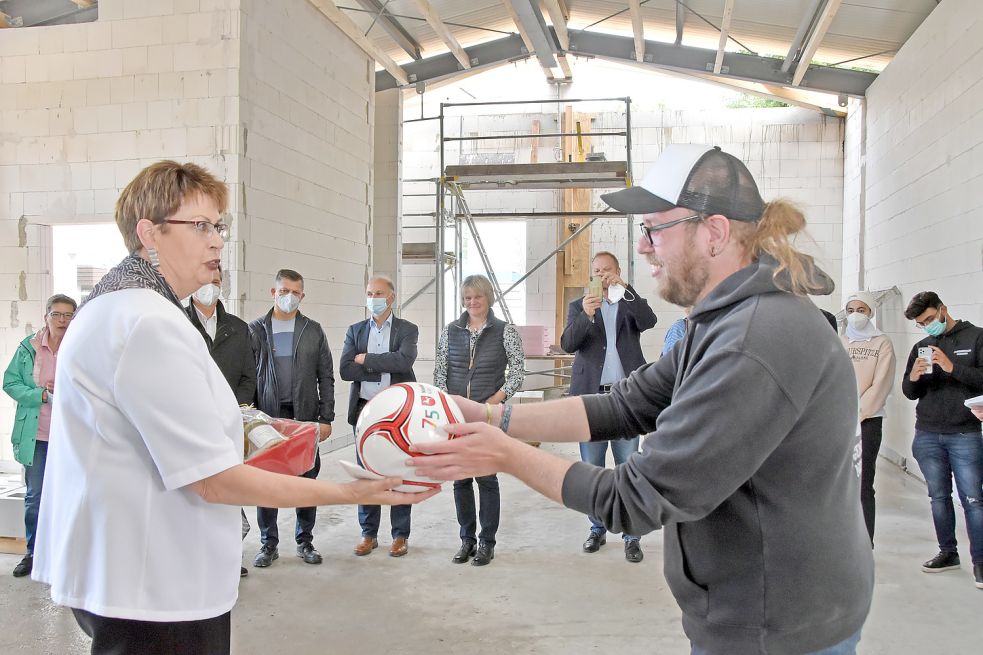 Ministerin Birgit Honé überreichte Jugendhausleiter André Janssen bei ihrem Besuch auf der Baustelle einen Fußball und einen Präsentkorb. Foto: Thomas Dirks