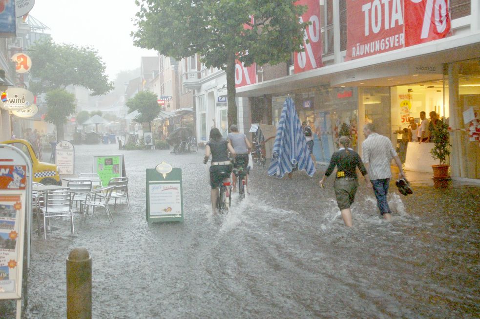 Durch die Burgstraße ging es am 6. Juli 2006 nur mit hoch gekrempelten Hosen. Das Modehaus Silomon hatte mit dem Wasser zu kämpfen. Archivfoto: Romuald Banik