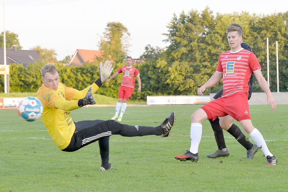 Der Schuss des Aurichers Mittelfeldspielers Andreas Flessner (rotes Trikot) verfehlte das Tor von Weene nur knapp. TuS-Torwart Joost Freitag hatte die Nerven behalten und das Tor für den Angreifer möglichst klein gemacht. Foto: Bernd Wolfenberg