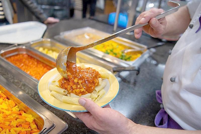 Ein Koch serviert in der veganen Mensa auf dem Campus der Technischen Universität in Berlin ein veganes Gericht. Foto: Monika Skolimowska/dpa-Zentralbild/dpa