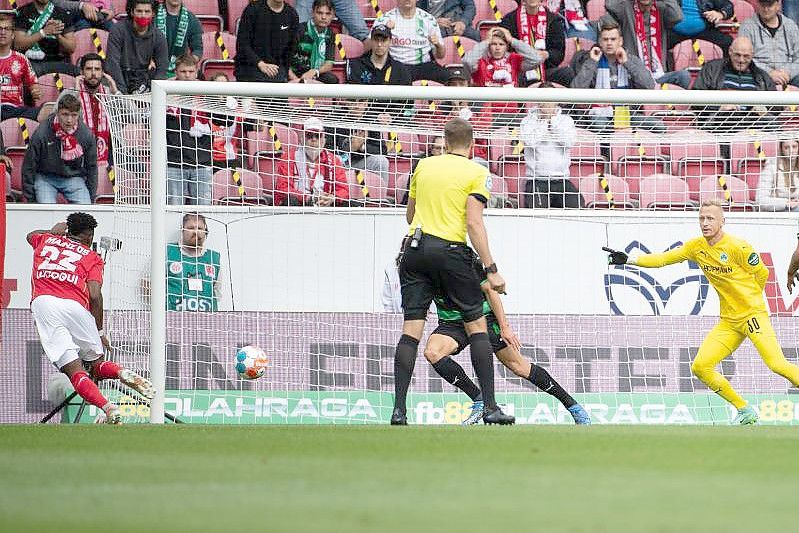 Der Mainzer Anderson Lucoqui (l) erzielt den 1:0-Führungstreffer - Fürths Torwart Sascha Burchert (2.v.r.) kann das Gegentor nicht mehr verhindern. Foto: Sebastian Gollnow/dpa