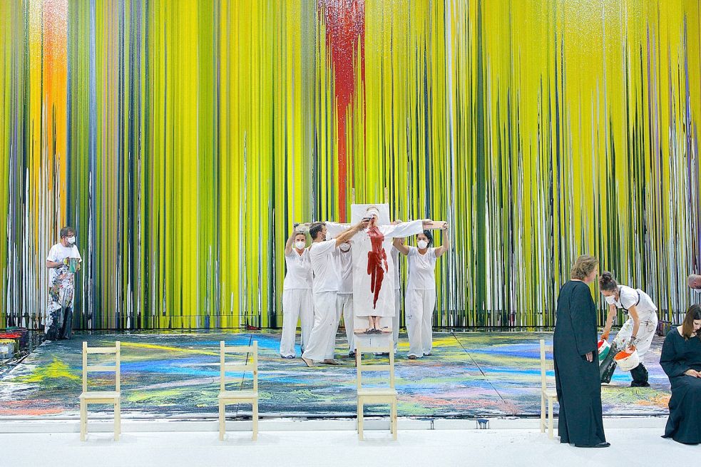 Jemand wird gekreuzigt, einige bemalen Boden und Wände mit dicker Farbe, und vorne sitzen Siegmund (Klaus Florian Vogt, vorne links) und Sieglinde (Lise Davidsen) - so sieht es aus, wenn Hermann Nitsch „Die Walküre“ in Bayreuth bebildern darf. Foto: Enrico Nawrath/Bayreuther Festspiele