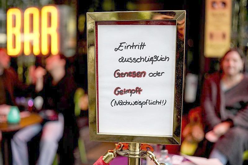 Vor einer Bar im Hamburger Stadtteil St. Georg steht ein Hinweisschild, welches auf den Einlass nach der 2G-Regel hinweist. Foto: Axel Heimken/dpa