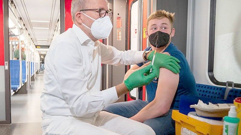 Christian Gravert, Chefmediziner der Deutschen Bahn, verabreicht einem Mann in einer Berliner S-Bahn den Impfstoff des Herstellers Johnson & Johnson. Foto: Christophe Gateau/dpa