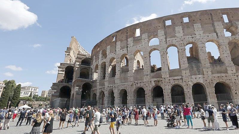 Touristen warten in einer Schlange, um das Kolosseum zu betreten. In Italien gelten ab diesem Mittwoch verschärfte Corona-Regeln. Foto: Riccardo De Luca/AP/dpa