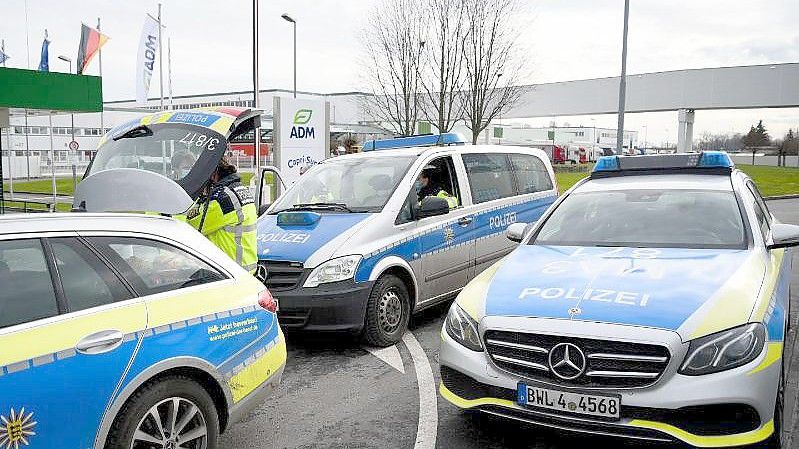 Fahrzeuge der Polizei stehen vor dem Werk eines Getränkeherstellers, wo eine Serie explosiver Postsendungen begannn. Jetzt wird wird einem 66-jährigen Elektriker der Prozess gemacht. Foto: Rene Priebe/dpa