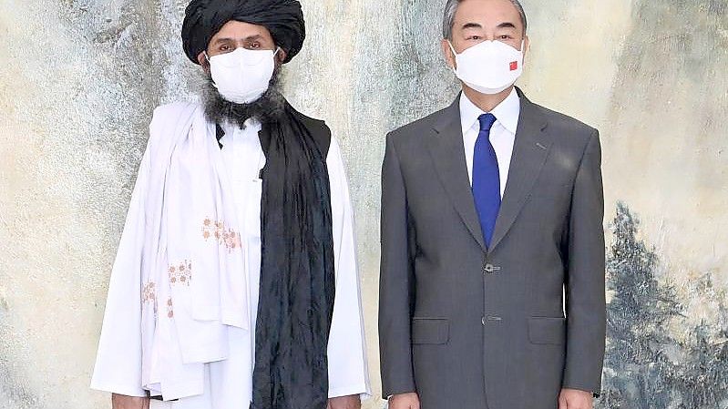 Chinas Außenminister Wang Yi (r) neben einem Führer der Taliban. Foto: Li Ran/XinHua/dpa