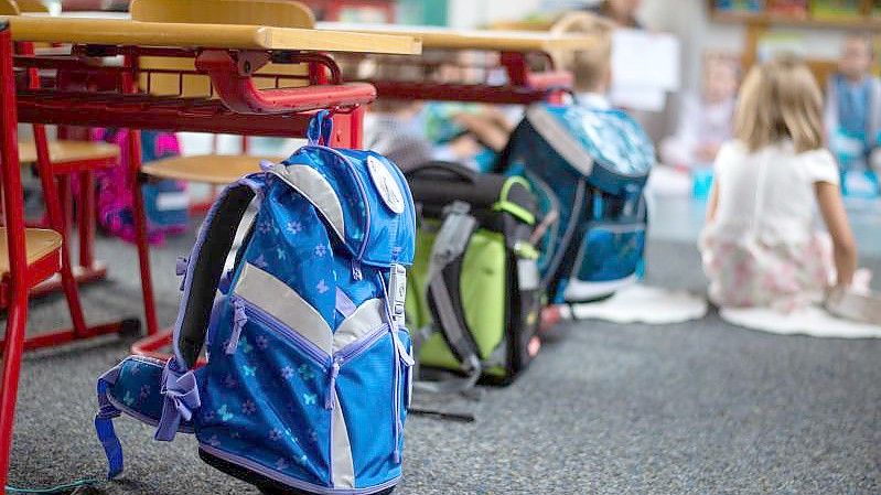 Ranzen hängen und stehen beim Begrüssungsunterricht der neuen Erstklässler im Klassenzimmer. (Archivbild). Foto: Philipp Schulze/dpa