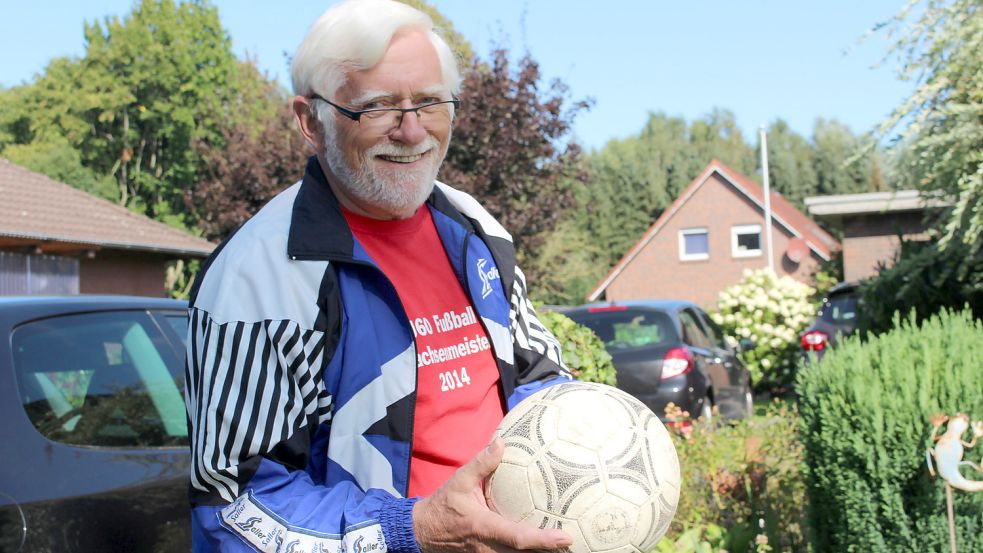 Alfred Meyer ist mit dem Fußballspielen in verschiedenen Vereinen unterwegs. Die blauweiße Jacke steht für seinen Heimatverein VfL Mullberg. Das rote Shirt mit der Aufschrift Ü60 Fußball Niedersachsenmeisterschaft 2014 gehört zur SG Muwies Ü60 Großefehn. Dort trägt er als Rechtsaußen die Rückennummer zwölf. Foto: Wolf-Rüdiger Saathoff