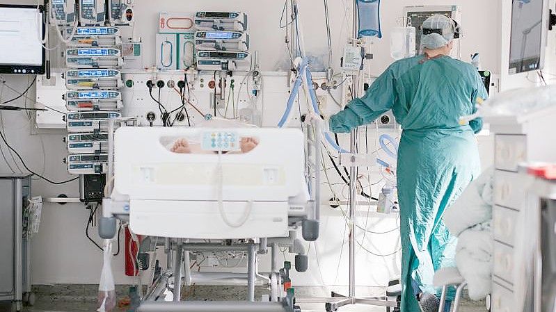 Eine Intensivpflegerin versorgt auf einer Braunschweiger Intensivstation einen an Covid-19 erkrankten Patienten. Foto: Ole Spata/dpa