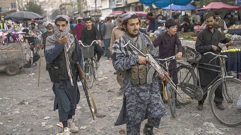 Taliban-Kämpfer patrouillieren auf einem Markt in der Altstadt. Foto: Bernat Armangue/AP/dpa