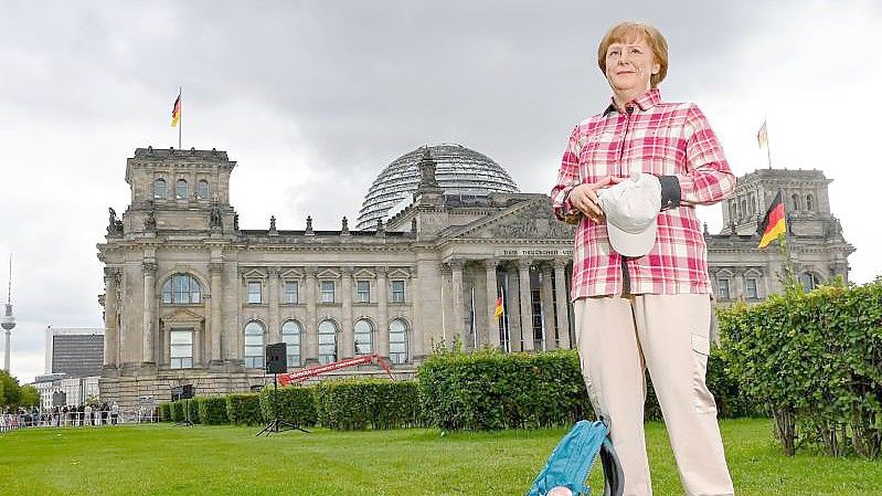 Die Wachsfigur von Bundeskanzlerin Angela Merkel (CDU) vor dem Reichstagsgebäude in Berlin. Foto: Jens Kalaene/dpa-Zentralbild/dpa