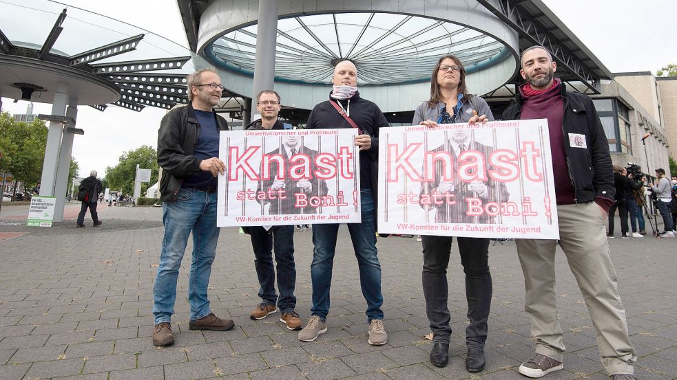 „Knast statt Boni“: VW-Mitarbeiter demonstrieren mit einem Plakat vor der Stadthalle Braunschweig, wo der Strafprozess des Landgerichts Braunschweig gegen vier Angeklagte im VW-Abgasskandal begonnen hat. Foto: Julian Stratenschulte/dpa