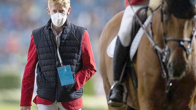 Der verletzte Reiter Marcus Ehning geht neben Daniel Deußer nach dessen Ritt aus dem Stadion. Foto: Rolf Vennenbernd/dpa