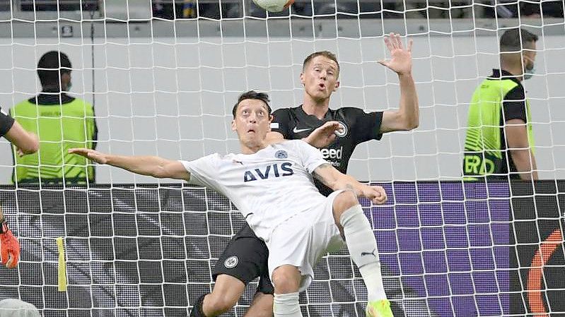 Frankfurts Erik Durm (r) und Istanbuls Mesut Özil kämpfen um den Ball. Foto: Arne Dedert/dpa