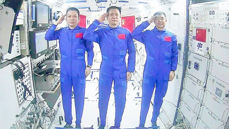 Die Astronauten Tang Hongbo (v.l.n.r.), Nie Haisheng und Liu Boming salutieren in der Raumstation „Tiangong“. Foto: Yue Yuewei/XinHua/dpa/Archiv