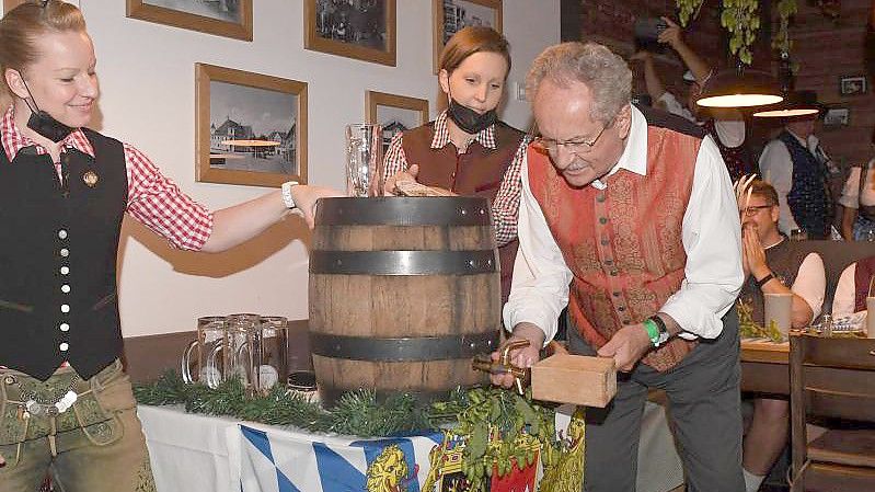 Christian Ude zapft im Schiller Bräu mit zwei Schlägen an. Foto: Felix Hörhager/dpa