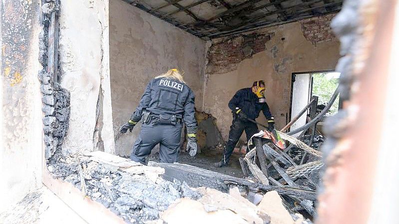 Zwei Brandermittler der Polizei im Einsatz. Foto: Jonas Walzberg/dpa