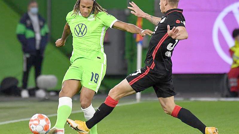 Wolfsburgs Kevin Mbabu (l) im Zweikampf mit Frankfurts Erik Durm. Foto: Swen Pförtner/dpa