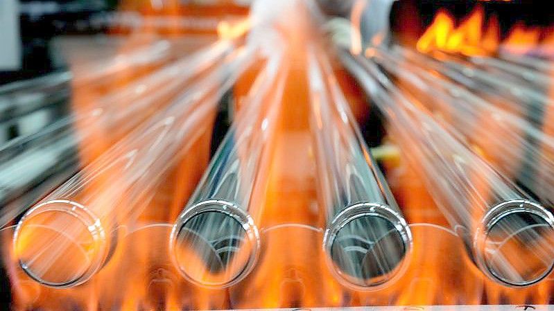 Glasröhren für Leuchtstoffröhren laufen in der Produktion eines Lampenherstellers über ein Band. Foto: Hendrik Schmidt/dpa-Zentralbild/dpa