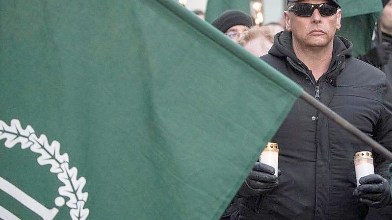 Mit Fahnen und Kerzen in der Hand gehen Demonstrationsteilnehmer der rechtsextremen Kleinstpartei „Der dritte Weg“ während eines Marsches durch die Innenstadt von Fulda. Foto: Boris Roessler/dpa