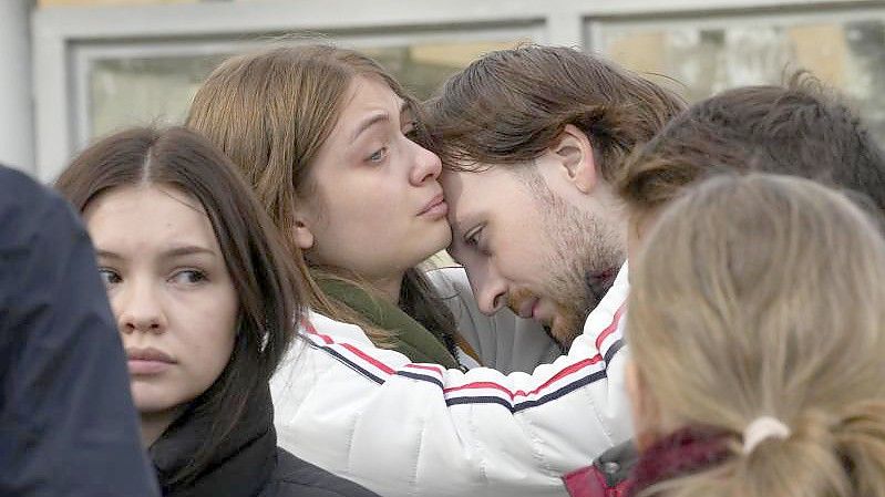 Studenten trösten sich gegenseitig während einer Versammlung nach der Schießerei auf dem Campus der Staatlichen Universität Perm. Foto: Dmitri Lovetsky/AP/dpa