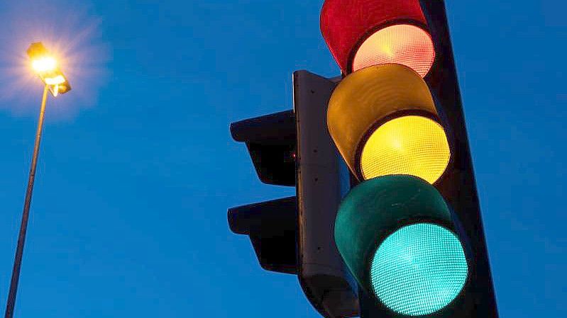 Eine Ampel zeigt am frühen Morgen die Farben rot, gelb und grün. Foto: Marijan Murat/dpa