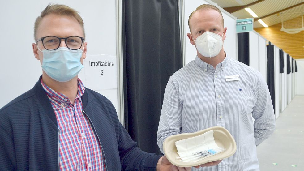 Der Leiter des Impfzentrums, Norman Büchter (rechts) und Thomas Bongert vom Krisenstab des Landkreises mit einem Set Spritzen im Impfzentrum in Georgsheil. Foto: Aiko Recke