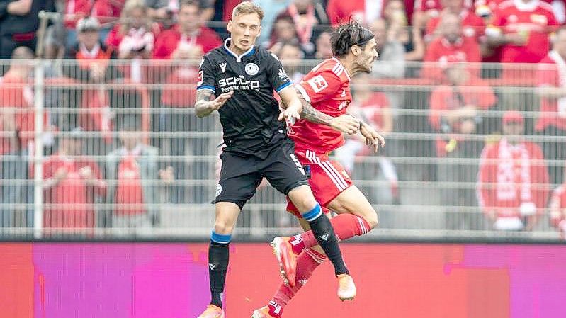 Jacob Barrett Laursen von Arminia Bielefeld springt gegen Berlins Christopher Trimmel (r) zum Kopfball. Foto: Andreas Gora/dpa