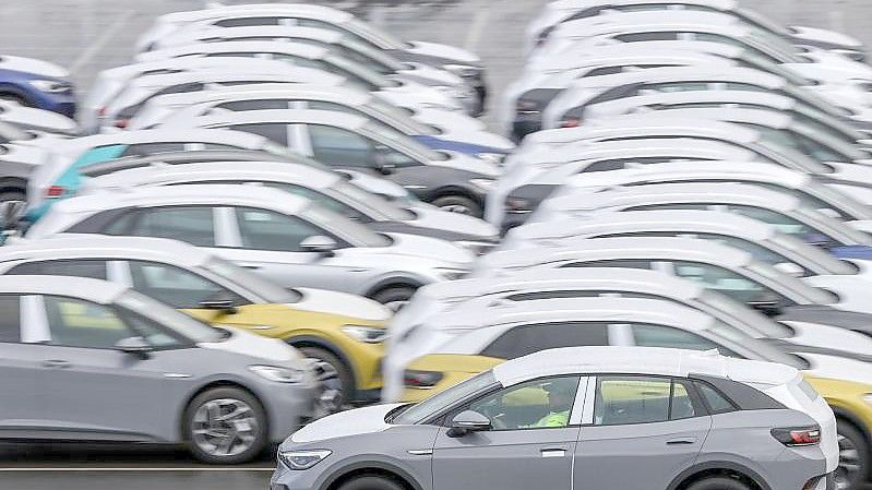 Ein Volkswagen ID.4 fährt zur Auslieferung über einen Zwickauer Parkplatz mit weiteren Neuwagen. Foto: Jan Woitas/dpa-Zentralbild/dpa