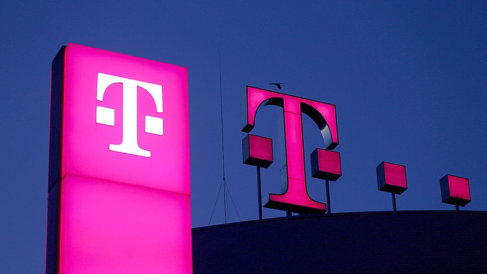 Das Logo der Deutschen Telekom leuchtet auf dem Dach der Unternehmenszentrale. Foto: DPA
