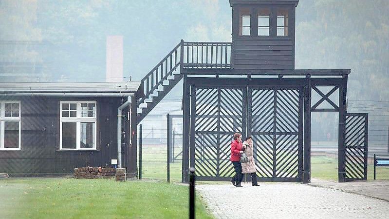 Besucher gehen am Eingang des Stutthof Museums in Sztutowo (Polen) vorbei, in dem an die Verbrechen im ehemaligen deutschen Konzentrationslager Stutthof erinnert wird. Foto: Piotr Wittman/PAP/dpa