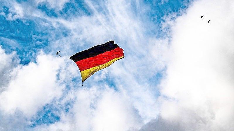 Über dem Flughafen Paderborn-Lippstadt hissen sieben Fallschirmspringer eine Flagge, die so groß ist wie niemals zuvor bei einem Sprung. Foto: David Inderlied/dpa