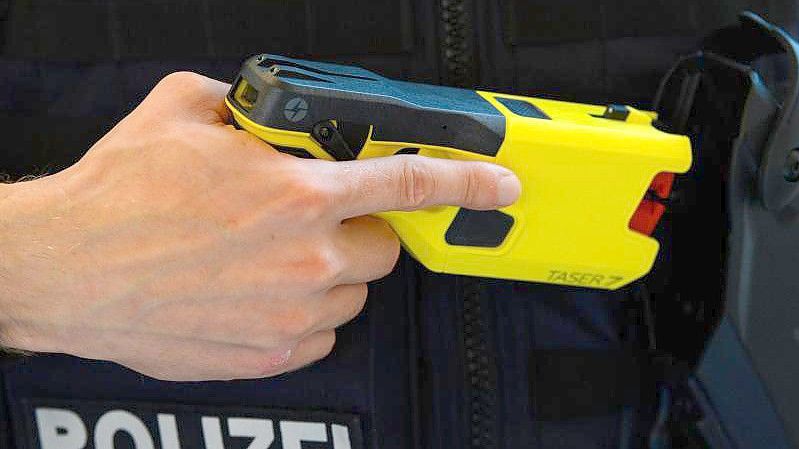 Ein Polizeibeamter präsentiert einen Taser. Foto: Soeren Stache/dpa-Zentralbild/dpa