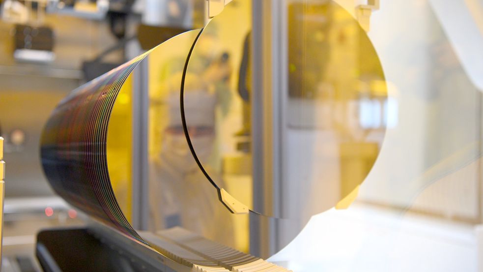 Ein Mitarbeiter spiegelt sich in der neuen Halbleiterfabrik von Bosch im Reinraum in einem 300-Millimeter-Wafer. Der Technologiekonzern Bosch hat in Dresden im Juli eine neue Halbleiterfabrik in Betrieb genommen. Foto: DPA
