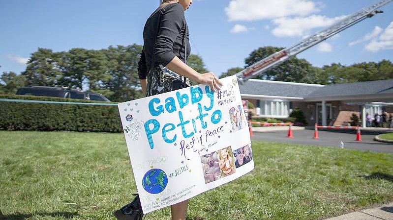 Eine Frau trägt während der Trauerfeier am 26. September ein Plakat zu Ehren Petitos. Foto: Eduardo Munoz Avarez/AP/dpa