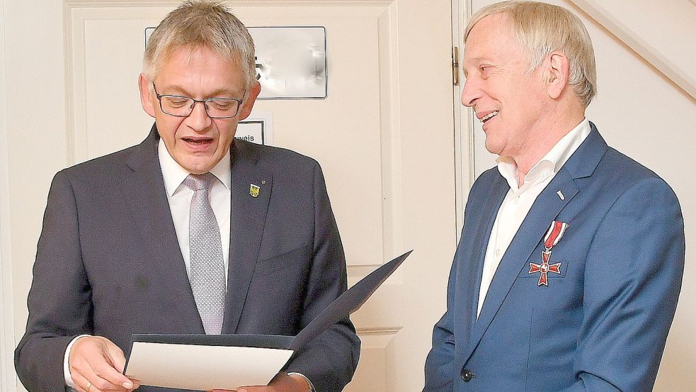 Landrat Olaf Meinen überreichte Bernd Buttjer das Verdienstkreuz und las aus der Verleihungsurkunde vor. Foto: Gerd-Arnold Ubben