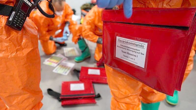 Einsatzkräfte des Havariekommandos bereiten sich während einer Großübung zur Vorbereitung auf Notfälle im Seuchenschutz im Hamburger Hafen auf ihren Einsatz vor. Foto: Marcus Brandt/dpa