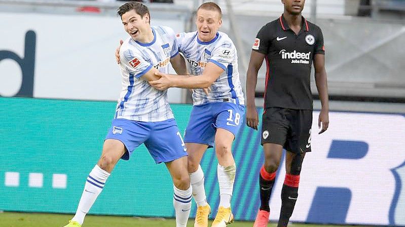 Herthas Torschütze Jürgen Ekkelenkamp (l-r) und Santiago Ascacibar jubeln nach dem Tor zum 2:0 neben Frankfurts Evan Ndicka. Foto: Arne Dedert/dpa