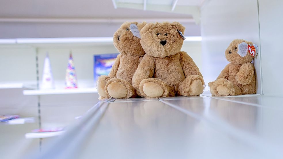 Drei Teddybären sitzen auf einem ansonsten leeren Verkaufsregal. Symbolfoto: DPA/Jens Büttner