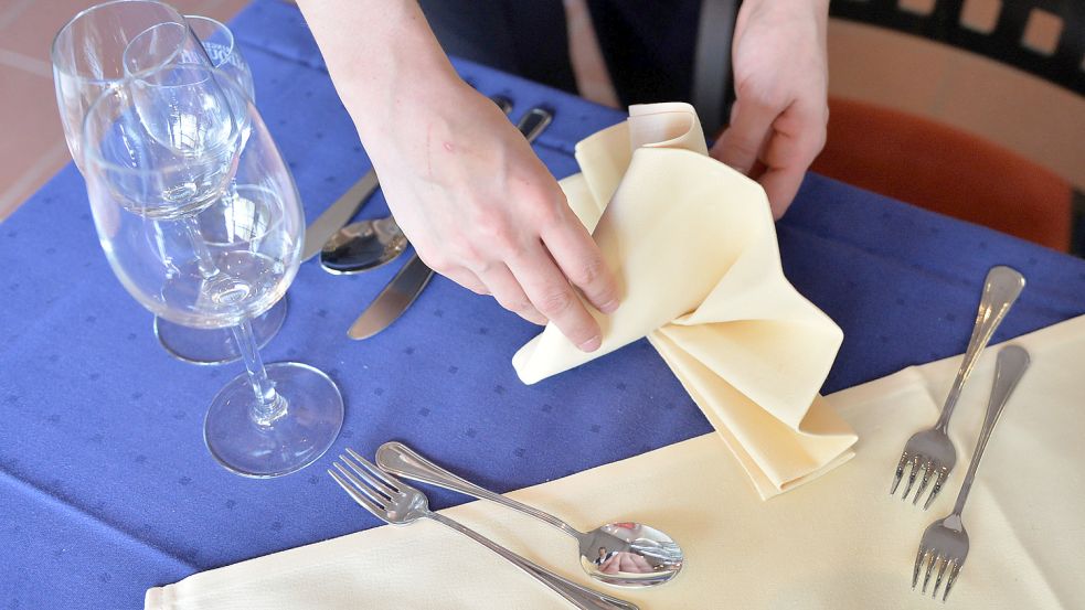 Ein Tisch wird eingedeckt. In der Auricher Gastronomie laufen wieder Buchungen für Weihnachtsfeiern ein. Foto: DPA