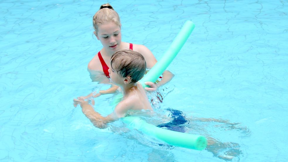 Eine Ausbilderin übt mit einem Kind das Schwimmen. Foto: DLRG