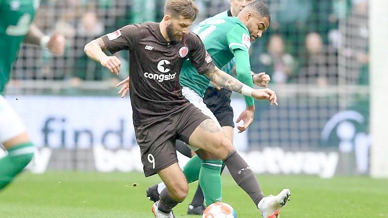 Pauli-Torjäger Guido Burgstaller (vorne) schirmt den Ball gegen Werders Jean Manuel Mbom ab. Foto: Carmen Jaspersen/dpa