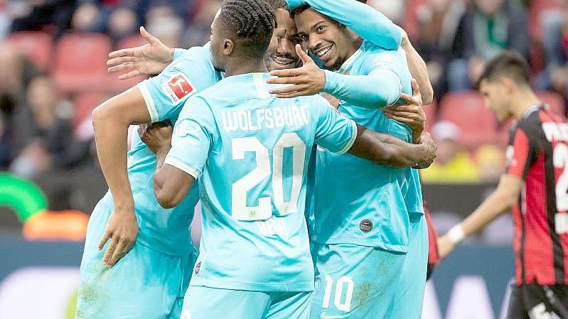 Wolfsburgs Lukas Nmecha (r) lässt sich für sein Tor zum zwischenzeitlichen 1:0 in Leverkusen feiern. Foto: Federico Gambarini/dpa