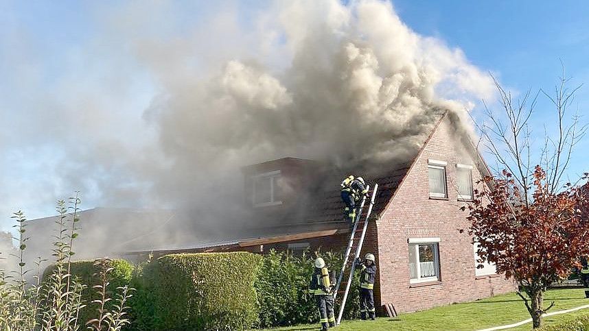 Dicke Qualmwolken steigen aus dem brennenden Einfamilienhaus auf. Foto: Holger Janssen