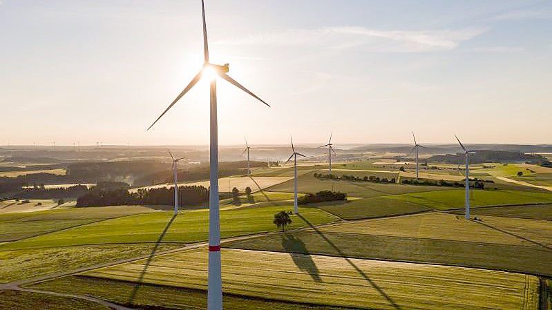 Windräder stehen während des Sonnenaufgangs auf einem Feld. Immer mehr Anleger an den Aktienbörsen interessieren sich für Nachhaltigkeitsfonds. Foto: Tom Weller/dpa